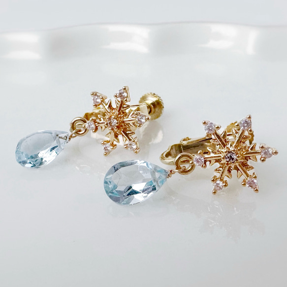 雪の結晶と揺れるクリアスカイブルートパーズのかわいいイヤリング