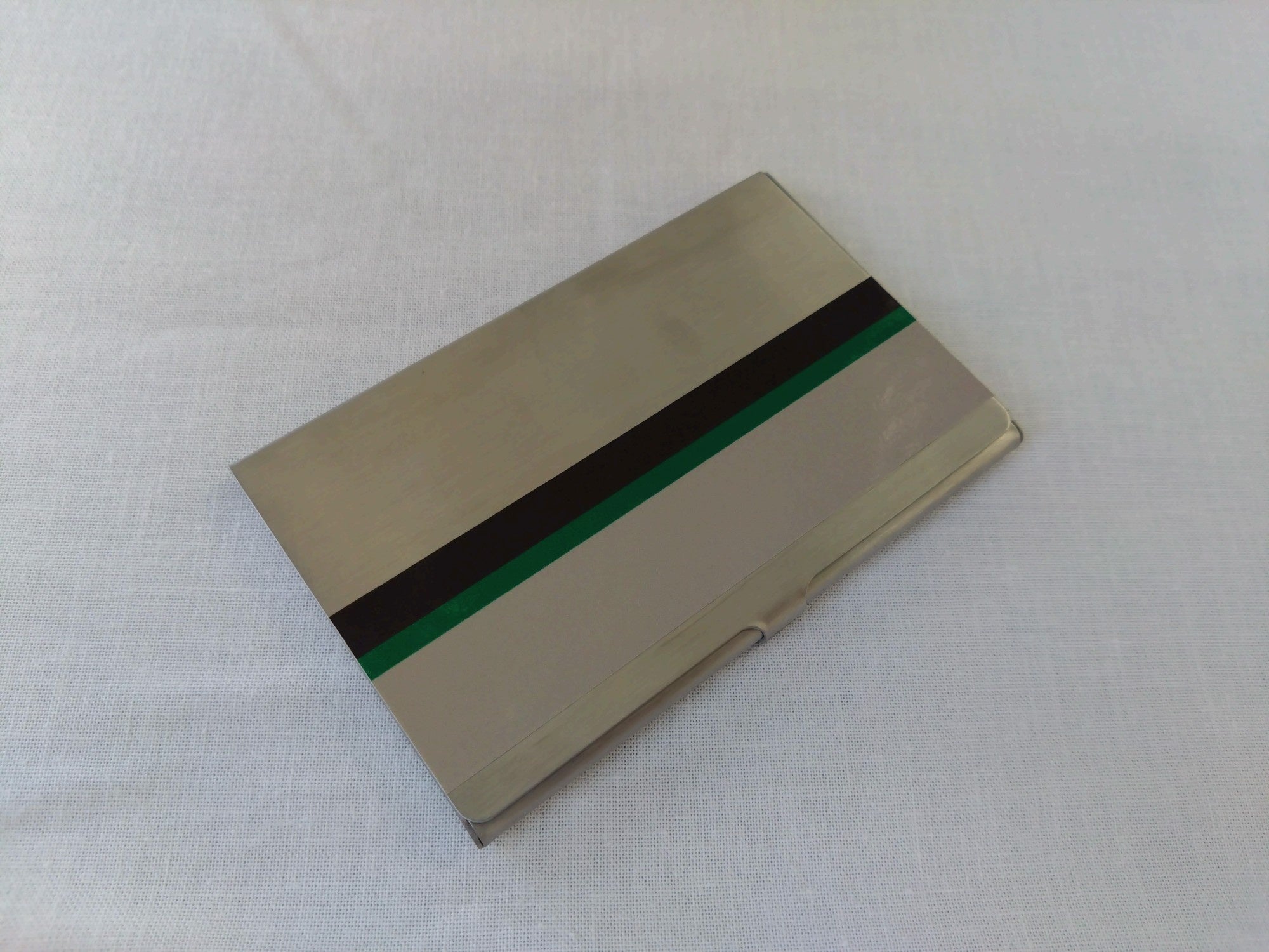 素材もデザインも本物の鉄道車両帯シールを使用したステンレス製名刺